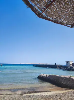 a beach with people swimming in the water at Oriental Tail Home in Hurghada