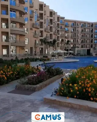 a large apartment building with flowers in a courtyard at CAMUS 343, Princess Resort in Hurghada