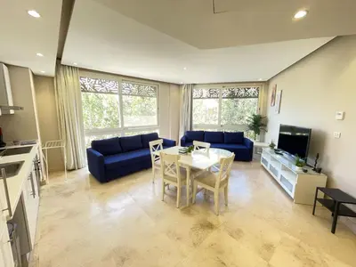a living room with a table and a blue couch at El Gouna Mangroovy 1-Bedroom Sleeps 4-Persons, M8-4C-14 in El Gouna