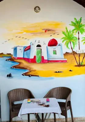 a painting of a room with a table and chairs at Bakar Nubian Guest House in Aswan