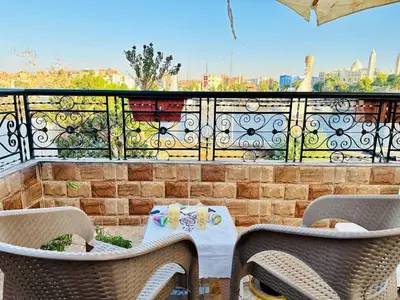 a patio with a table and chairs on a balcony at Bakar Nubian Guest House in Aswan