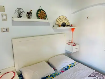 a small bedroom with a bed and shelves at Bakar Nubian Guest House in Aswan
