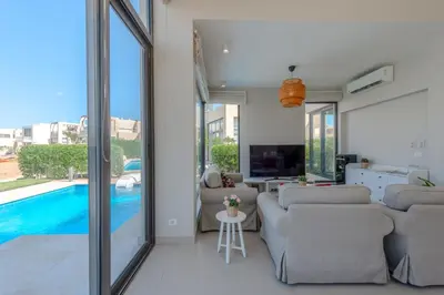 a living room with couches and a swimming pool at Elegant 4BR in Tawila, Gouna. Private Pool, Lagoon in Hurghada
