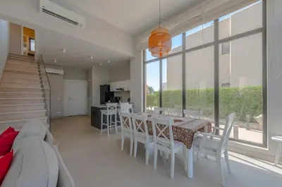 a dining room with a table and white chairs at Elegant 4BR in Tawila, Gouna. Private Pool, Lagoon in Hurghada