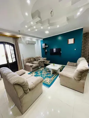 a living room with couches and a blue wall at El Hady Apartments with Swimming Pool in Luxor
