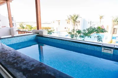 a swimming pool with blue tiles in a building at Makadi Heights Elite Worldwide Residences - Hurghada, Egypt in Hurghada