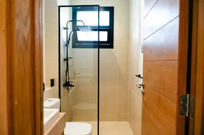 a bathroom with a toilet and a glass shower door at Makadi Heights Elite Worldwide Residences - Hurghada, Egypt in Hurghada