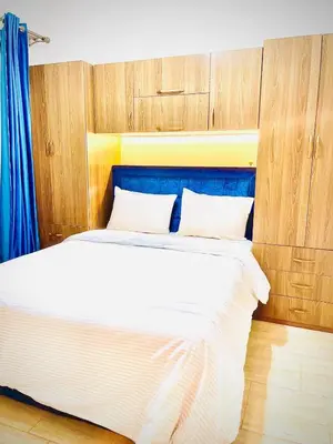 a bedroom with a large white bed with wooden cabinets at Luna Blu Sea View in Hurghada
