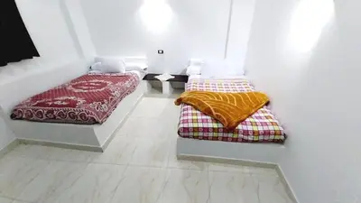 two beds are sitting in a room with a floor at Magic Place Luxor in Luxor