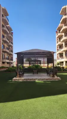 a gazebo with benches in front of a building at Wa set Luxor Apartment in Luxor