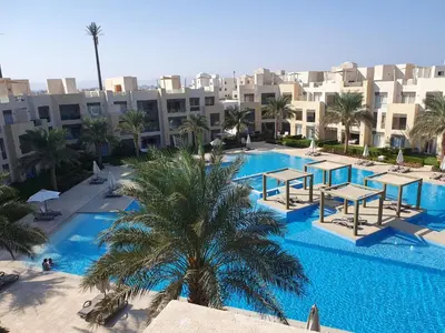 an overhead view of a pool with palm trees and buildings at Mangroovy 2BR with roof in Hurghada