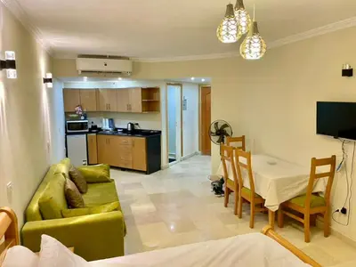 a living room with a couch and a table and a kitchen at Top floor premier view chalet in Red sea Hurghada in Hurghada
