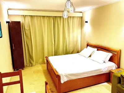 a bedroom with a bed with white sheets and a chandelier at Top floor premier view chalet in Red sea Hurghada in Hurghada