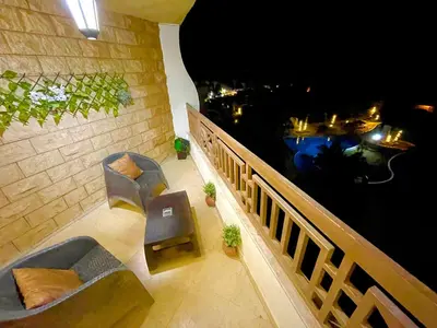 a balcony with a view of the water at night at Top floor premier view chalet in Red sea Hurghada in Hurghada