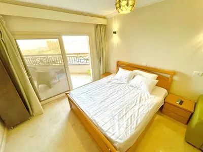 a bedroom with a bed with a view of a balcony at Top floor premier view chalet in Red sea Hurghada in Hurghada