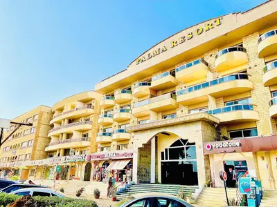 a large building with cars parked in front of it at Top floor premier view chalet in Red sea Hurghada in Hurghada