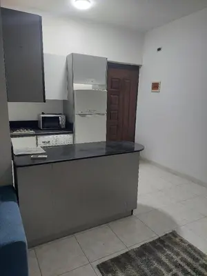 a kitchen with a counter top with a refrigerator at one bed Apartment In Al Makramia in Hurghada