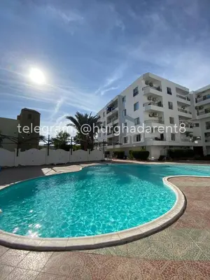 a swimming pool in front of a building at one bed Apartment In Al Makramia in Hurghada