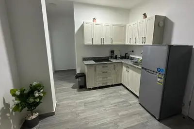 a kitchen with white cabinets and a refrigerator at Imperial Resort Apt Sleeps 3 - Pool Parking Wifi in Hurghada