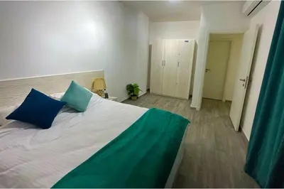 a bedroom with a large bed with two blue pillows at Imperial Resort Apt Sleeps 3 - Pool Parking Wifi in Hurghada