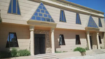 a building with blue windows on the side of it at Pyramids Luxor Hotel & SPA in Luxor