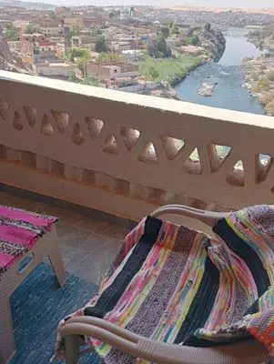 a balcony with a bench and a view of a river at Nubian Hights guesthouse in Shellal
