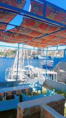 a picnic table under a tent next to the water at Onaty Narty Guest house Nile view in Aswan