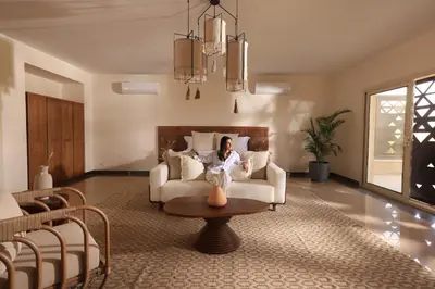 a woman sitting on a couch in a living room at The Zen Wellness Resort in Aswan