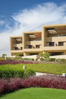 an apartment building with a garden in front of it at The Zen Wellness Resort in Aswan