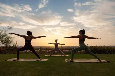 a group of women doing yoga in the grass at The Zen Wellness Resort in Aswan