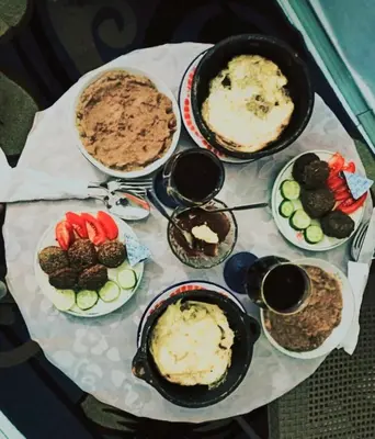 a table topped with plates of food on a table at Nubian Amego Gaust House in Aswan