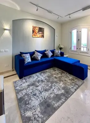 a blue couch in a living room with a rug at SunShine Y1-1-19 in Hurghada