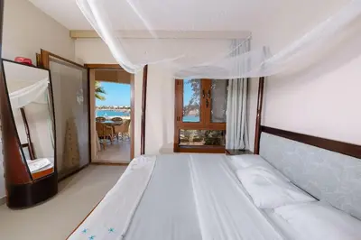 a white bed in a room with a view of the ocean at Sabina Lagoon view 2BR Apartment in Hurghada