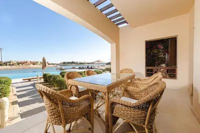 a dining room with a table and chairs on a patio at Sabina Lagoon view 2BR Apartment in Hurghada