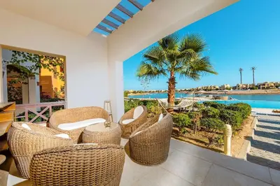 a porch with wicker chairs and a view of the ocean at Sabina Lagoon view 2BR Apartment in Hurghada