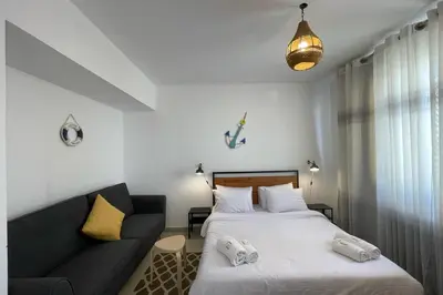 a bedroom with two beds and a couch at The Senseful Studio G Cribs in Hurghada
