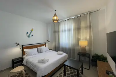 a bedroom with a bed and a table and a lamp at The Senseful Studio G Cribs in Hurghada