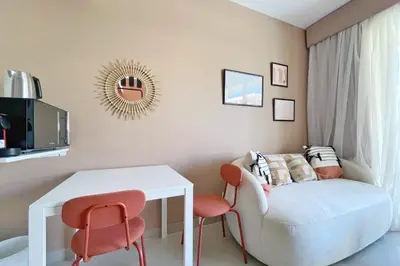 a living room with a white chair and a table at The Snuggly Studio G Cribs El Gouna in Hurghada