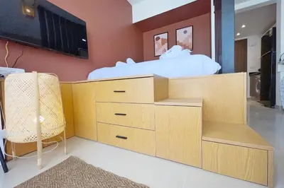 a bedroom with a bed with a tv and a chair at The Snuggly Studio G Cribs El Gouna in Hurghada