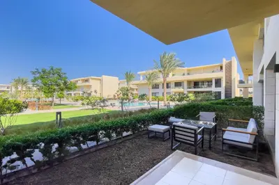 a patio with a table and chairs and a building at Cordial & Cozy 1 BDR G Cribs in Hurghada