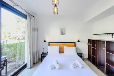 a bedroom with a bed and a large window at Cordial & Cozy 1 BDR G Cribs in Hurghada