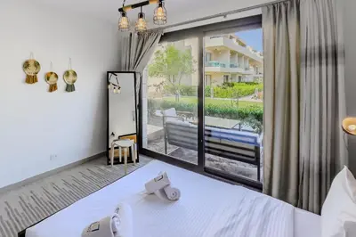 a bedroom with a bed and a large window at Cordial & Cozy 1 BDR G Cribs in Hurghada
