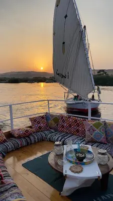 a table on the deck of a boat with a sail at Freedom Houseboat in Aswan