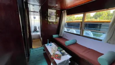 a train car with a bench and a table at Freedom Houseboat in Aswan