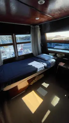 a bed in the middle of a room on a boat at Freedom Houseboat in Aswan