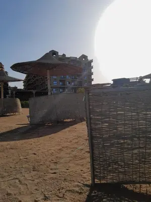 a fence on the beach with a building in the background at Turtles Beach resort hourghada Studio view sea view pool private beach Pools balcony security Cafe and restaurant on pool jacuzzi air-condition sunny a large balcony in Hurghada