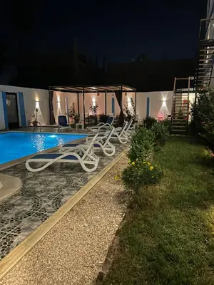 a swimming pool at night with a white apparatus next to it at Lemon Tree apartments luxor in Al Aqālitah