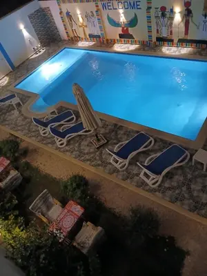 an overhead view of a swimming pool with chaise lounge chairs and a swimming pool at Lemon Tree apartments luxor in Al Aqālitah