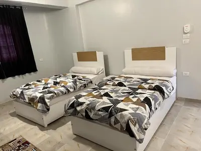 two beds sitting next to each other in a bedroom at Lemon Tree apartments luxor in Al Aqālitah
