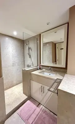 a bathroom with a sink and a shower with a mirror at SunShine AbuTig Marina in Hurghada